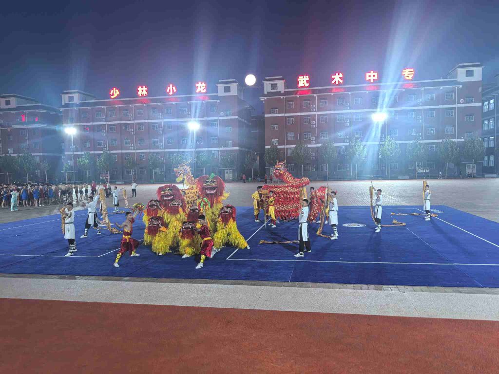 image shows students performing kung fu dance at night